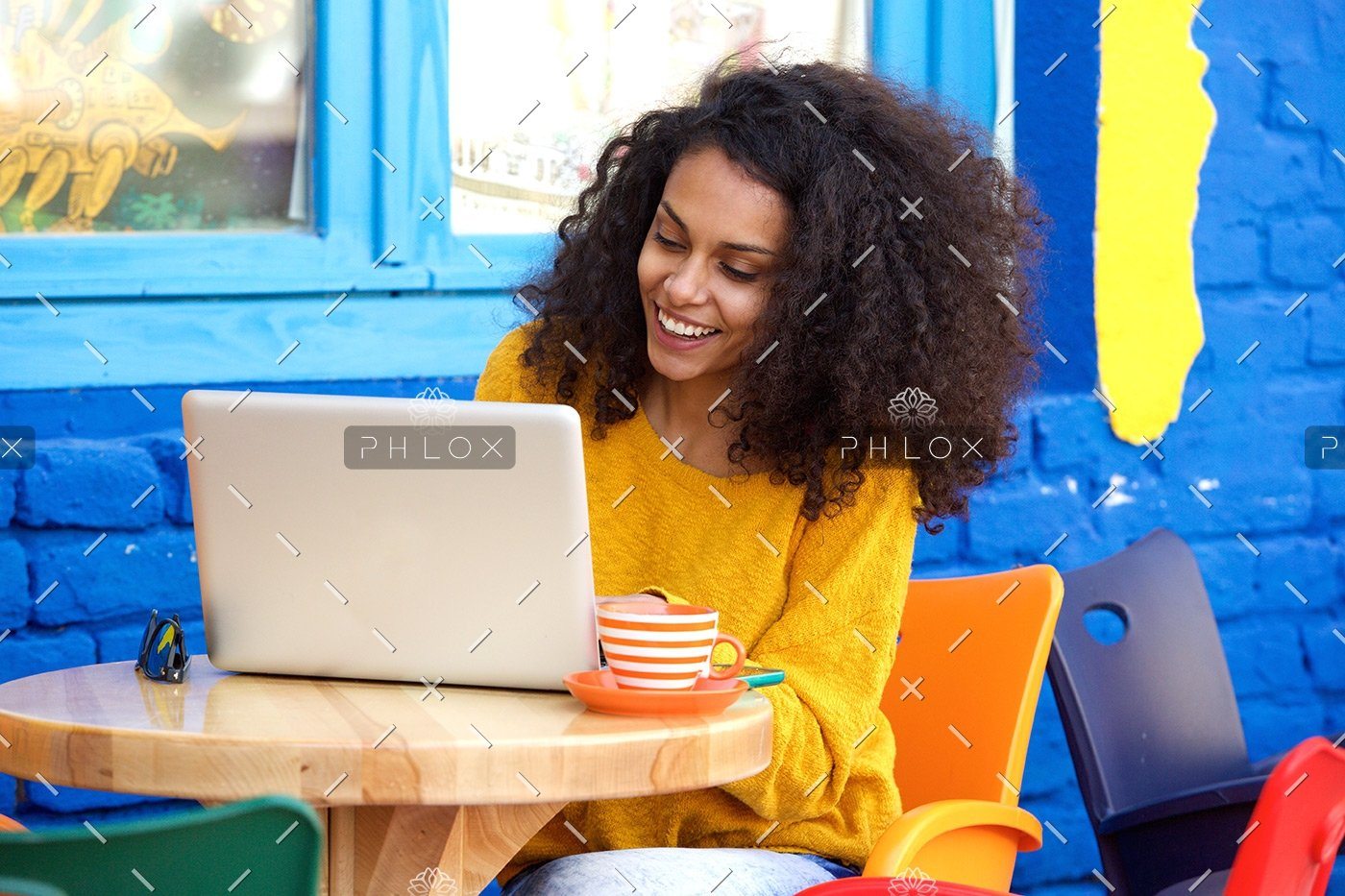 demo-attachment-29-happy-young-woman-sitting-at-outdoor-cafe-using-PFFBJ93